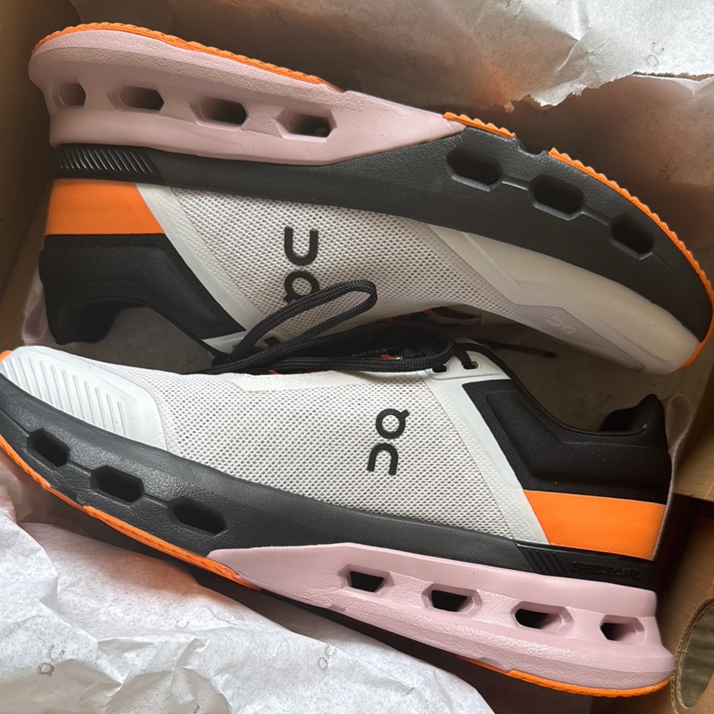 On Running Sneakers with White, Orange, and Black Accents